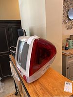 Side view showing the red translucent plastic casing and CRT screen depth