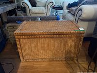 Front view of wicker trunk showing woven details and rectangular shape.