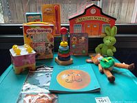 Photo of entire toy lot on blue surface including various educational and plush toys