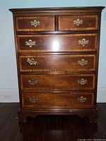 Front view of six-drawer mahogany dresser with banded detailing and brass hardware