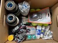Top view showing rolls of hockey tape, tennis balls, shoelaces, sneaker deodorizer balls, headlamp, and hockey skate sharpener in the box.