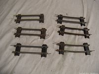 Six individual short sections of straight S Gauge train track, showing metal rails and plastic/metal sleepers, pins present but some bent, minor surface rust visible.