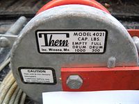 Close-up of the label on the winch showing brand Thern, model 4021, capacity ratings (empty drum 1000 lbs, full drum 300 lbs), and caution note.