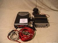 View of all items including Whistler inverter, Uniden CB radio, cables, and antenna coiled on top