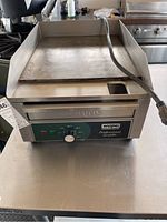 Front view of Waring Professional Griddle showing stainless steel surface and control panel with single knob and indicator lights.