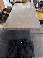 Top view of the solid travertine marble table surface, showing smooth finish and natural stone patterning in light beige tones.