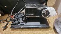 Photo showing Wonderwall projector resting atop Sony DVD player with power and AV cables visible.