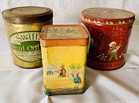 Three vintage advertising tins: Swift's Veal Cutlets, Thomas J. Lipton Tea, and a red cookie tin, showing patina and wear consistent with age