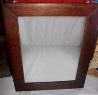 Front view of large oak framed vintage mirror showing wood grain and clear mirror glass.