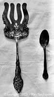 Photo showing the ornate serving fork and teaspoon together on a white background.