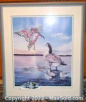 Framed limited edition print titled 'REUNION' depicting two geese on water, signed and numbered edition 21/45.