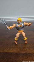 Front view of Battle Armor He-Man figure holding mace weapon, showing the armor and figure details.