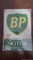 Rectangular metal BP sign showing logo and text with rust spots and patina
