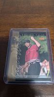 Front of Tiger Woods 1999 rookie trading card showing image and 'Tiger's Tales' text