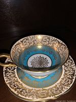 Blue Paragon tea cup inside matching saucer showing blue and gold patterns