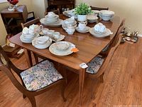 Wide view of table loaded with dinnerware and chairs