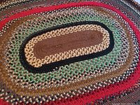 Close-up showing the detailed braided wool texture and color pattern in the rug center