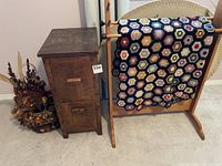 Full view of the small wooden side table, dried flower arrangement, and wooden towel stand with crochet throw draped over the stand.