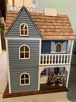 Front exterior view of assembled dollhouse showing painted siding, roof, and trim
