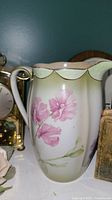 Close-up photo of vintage Brimwade water jug with pink floral pattern and gold scalloped rim showing some wear.
