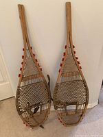 Front view of pair of wooden snowshoes leaning against wall
