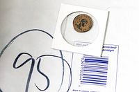 Ancient Roman coin enclosed in a protective holder showing the helmeted female bust and Latin inscriptions.