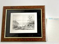 Front view of the framed black and white print featuring a river scene with a suspension bridge and people in the foreground.