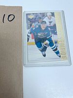 Upper Deck Corey Perry rookie hockey card showing Perry skating in Oregon Ducks teal jersey with gold foil "ROOKIE" text, card in clear protective sleeve.