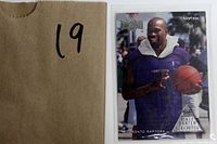 Card housed in a plastic sleeve next to a labeled envelope with the number 19