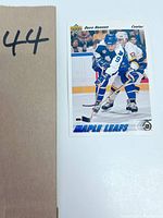 Photo of the hockey card showing Dave Hannan in a Toronto Maple Leafs uniform with game action background.
