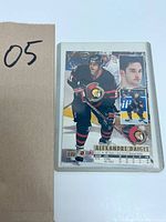 Front side of the hockey card featuring Alexandre Daigle in Ottawa Senators uniform, showing player images and statistics.