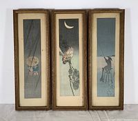 Full view of all three framed miniature Japanese art prints leaning against a white wall, showing their vertical rectangular wooden frames and distinct images.