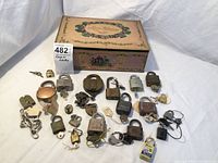 Overview of all vintage locks, keys, and the decorative candy tin used for storage. Includes 20+ locks made of brass and metal, with visible brand logos and attached keys.