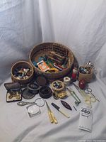 Full assortment laid out showing various sewing baskets, tins of buttons, scissors, needles, thimbles, safety pins, magnifier, tape measures, and other accessories.