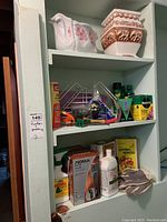 Photo of shelves with various gardening supplies including gloves, sprays, and boxed items.