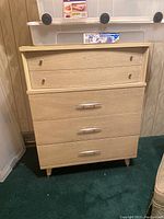 Front view of retro veneer dresser showing the five drawers and metal handles and knobs.