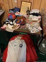 Overview photo of Shriners memorabilia laid out on table and jackets below