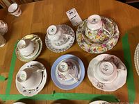 Top-down view of six teacups with matching saucers in various floral patterns showing size and arrangement