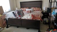 Full assembled bed frame with linens and packaging items on top