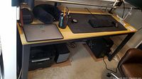 Table shown from an angle with laptop, keyboard, mouse, and desk accessories on top to illustrate size and surface.