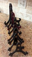 Photo showing several black wooden easels of various sizes including a dark reddish-brown easel arranged in decreasing size order on kitchen countertop.