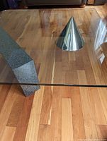 Overhead view showing glass top with rounded corners, granite base on left, aluminum cone on right