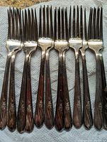 Close-up image of 8 forks showing tines and floral patterned handles.
