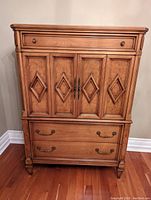 Full front view of tall dresser showing top drawer, cabinet doors with diamond panels, and two lower drawers