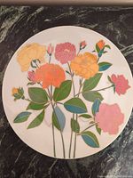 Full view of the round porcelain plate showing multicolored floral hand painted design with gold outlines on white background.