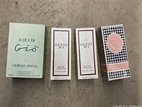 Four boxed perfumes arranged side by side: Acqua di Gio 50 ml, two Gucci No. 3 30 ml, Diorissimo 50 ml