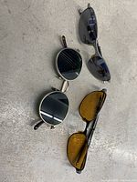 Top view of three pairs of sunglasses showing different frame shapes and lens colors.