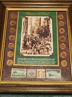 Framed piece showing entire collection with coins along side of historical photo and stamps below