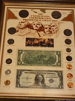 Full view of framed collection showing coins, bills, Mount Rushmore artwork, and historical painting