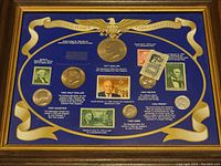 Framed collection of U.S. presidential coins and stamps mounted on blue background with gold decorative ribbon and eagle accents.
